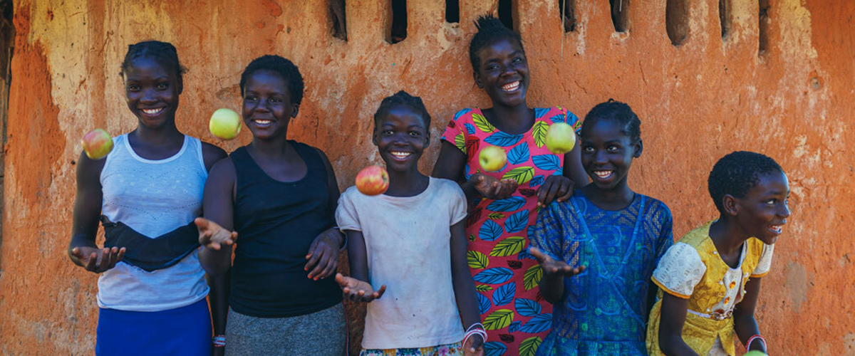 Girls smile and toss apples