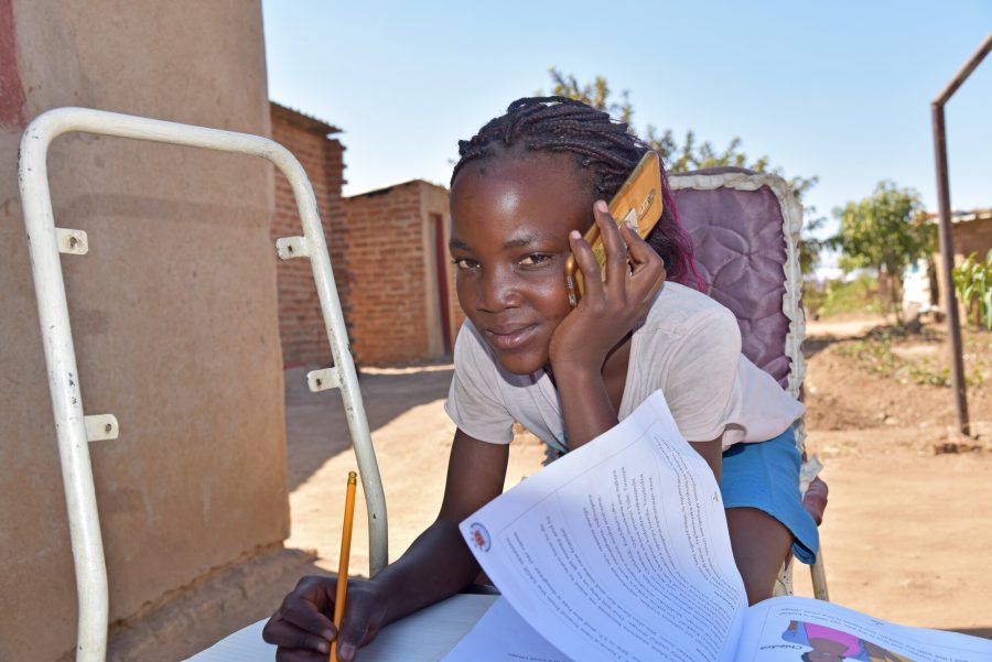 Yollanda, 12, uses her mobile phone to connect with a community educator