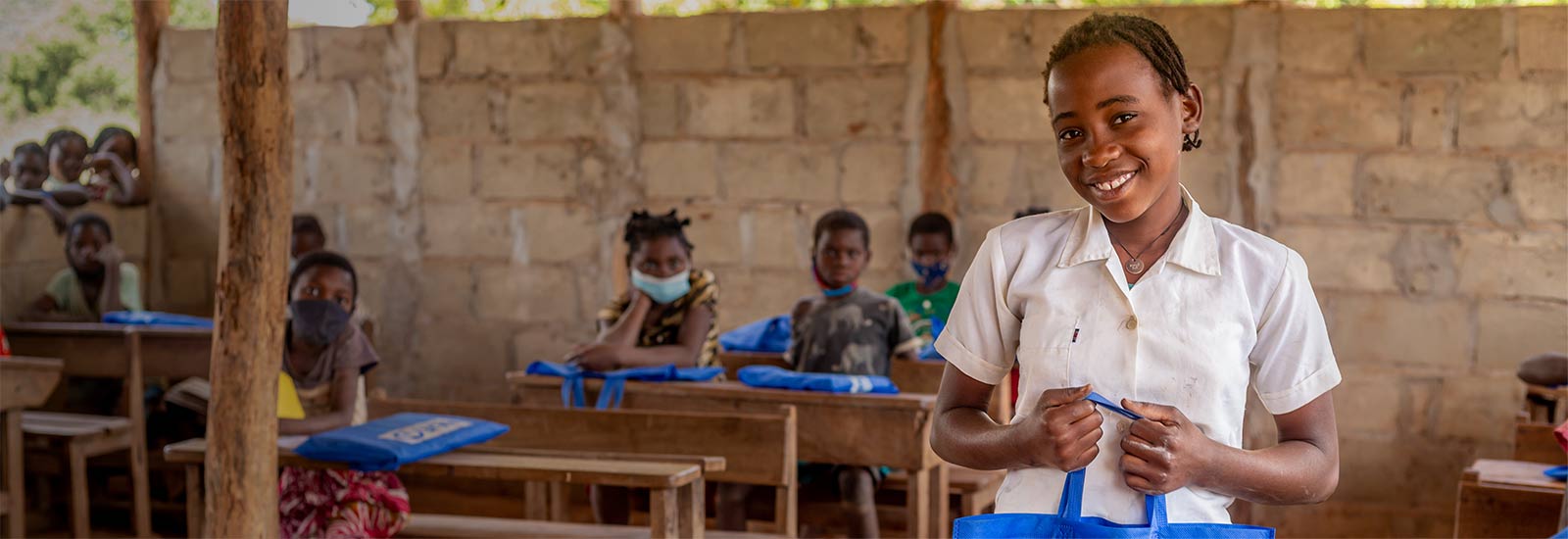 Amina, 11, with her school kit provided by Plan International