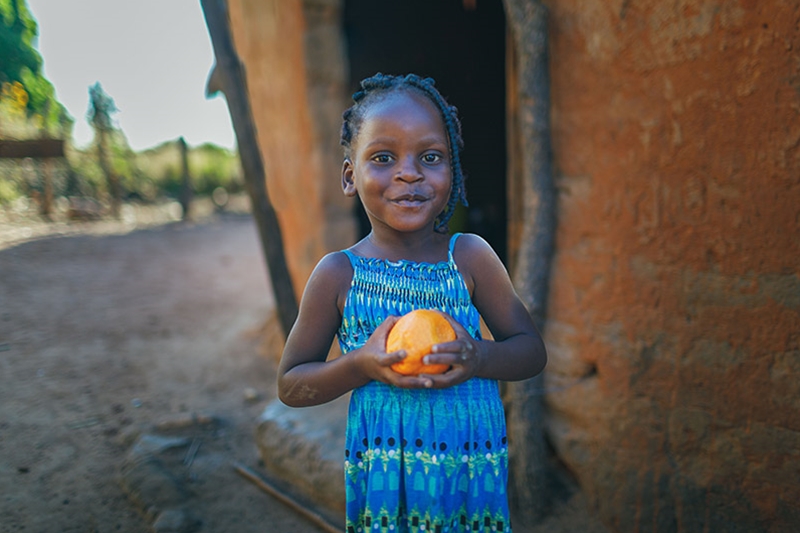 Danica, 10, collects water from the new pump installed by Plan International