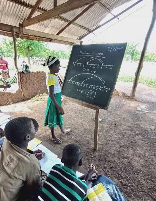 Ama at a chalkboard