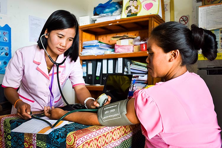 GoH FY 21 Train a female health worker - Midwife Amphai checks pregnant woman's blood pressure at health centre