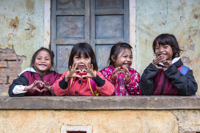 young-girls-holding-up-heart-signs-700x467