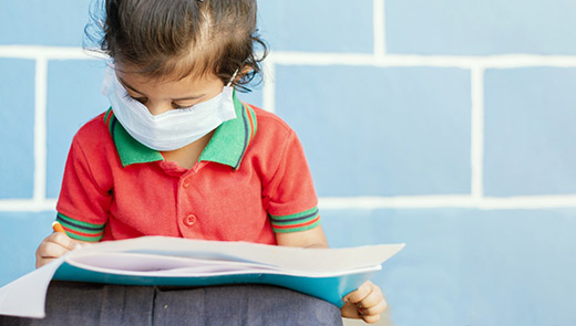 Child in mask reading