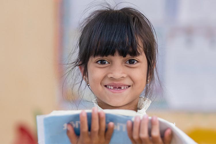 Girl reads from textbook at school in Kon Tum Province